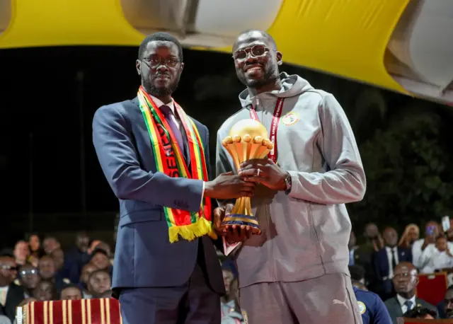 Le président sénégalais Bassirou Diomaye Faye et Khalidou Koulibaly avec le trophée de la CAN.