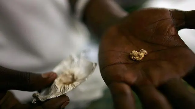 Une pépite d'or posée dans une paume humaine