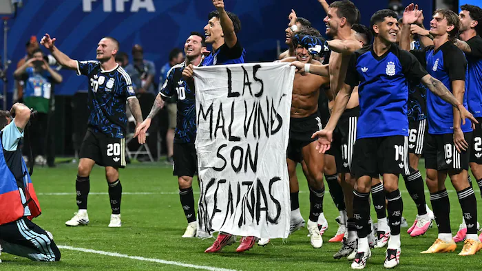 Des joueurs argentins brandissent une banderole 'les Malouines sont argentines' après le match.