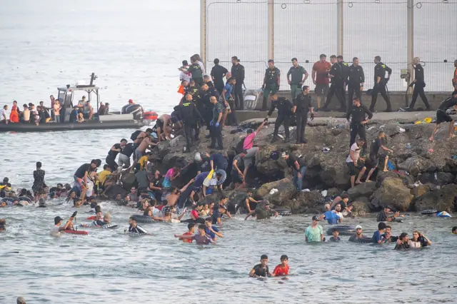 Foule de migrants tentant de franchir la frontière entre le Maroc et Ceuta